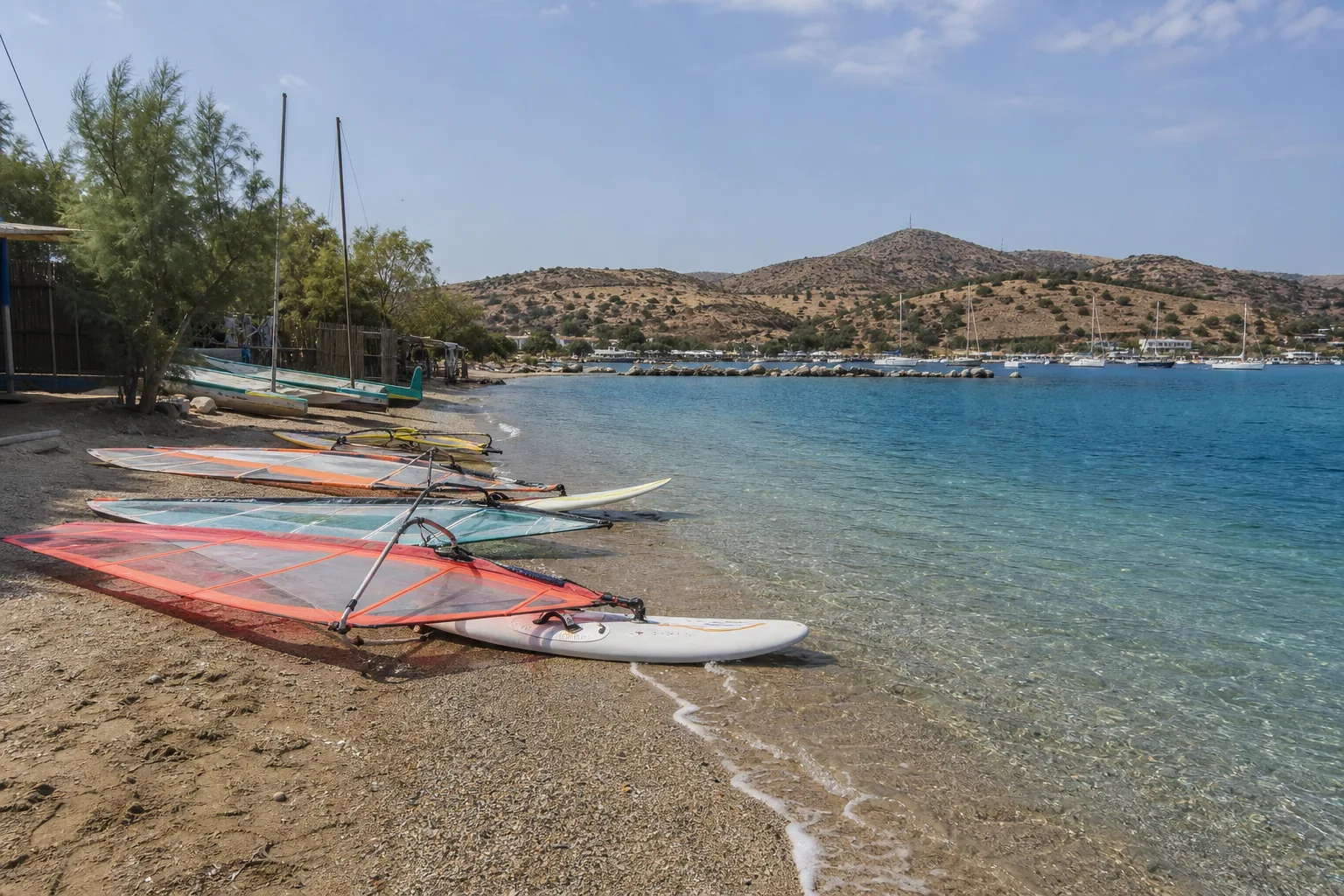 Ege kıyısında su kenarında derse hazır windsurf ekipmanları